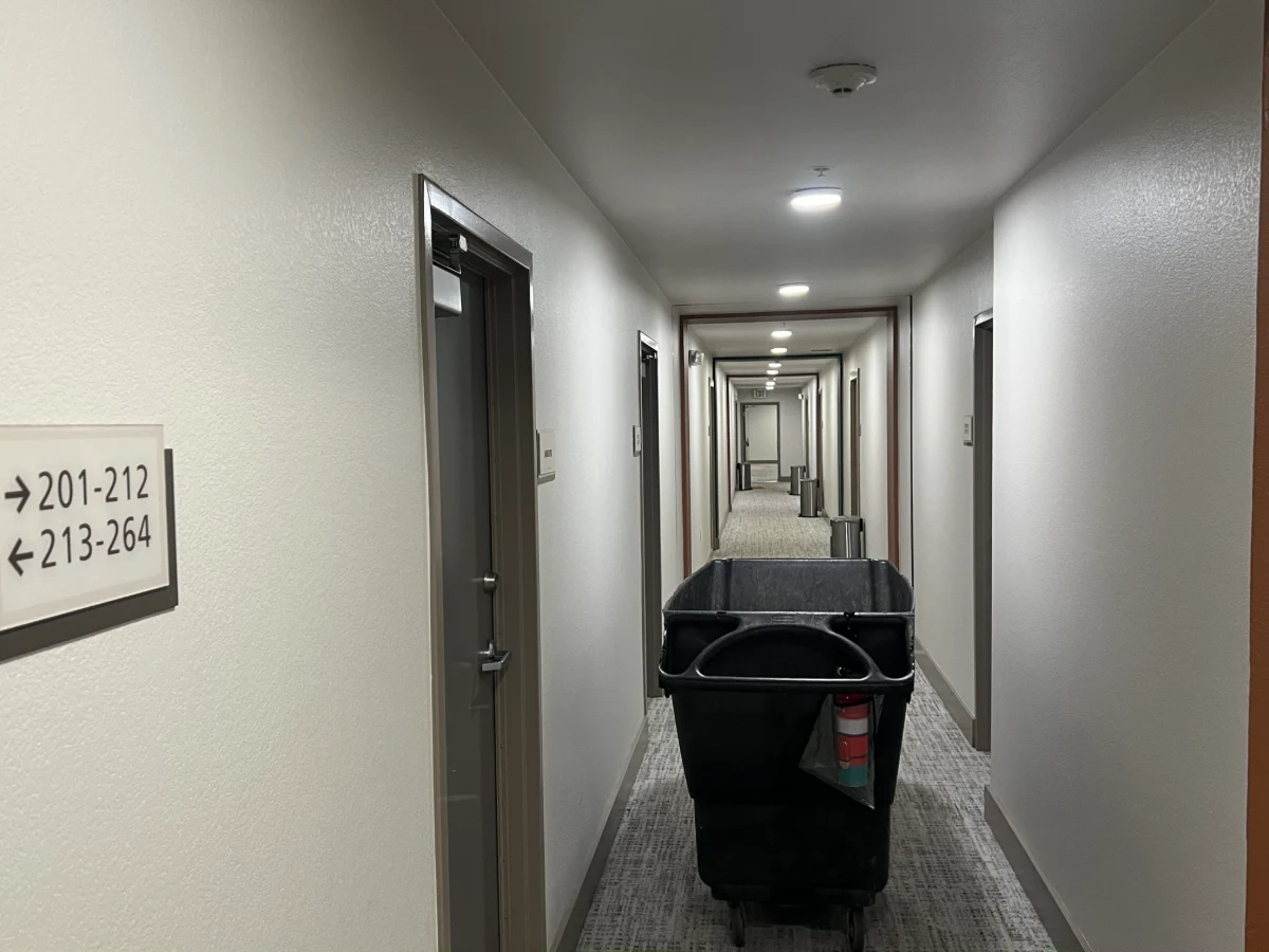 A trash-valet service cart in an apartment hallway, from the project’s image library